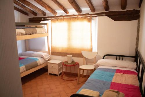 a bedroom with two bunk beds and a window at Casas rurales Puente Romano in Sonseca