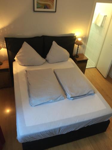 a bed with two pillows on it in a room at The Dubliner Hotel & Irish Pub in Heidelberg