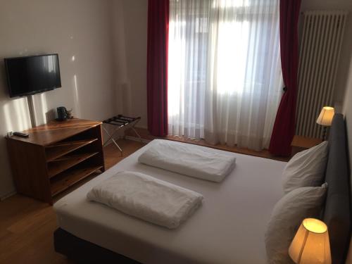 a bedroom with a bed with two pillows on it at The Dubliner Hotel & Irish Pub in Heidelberg