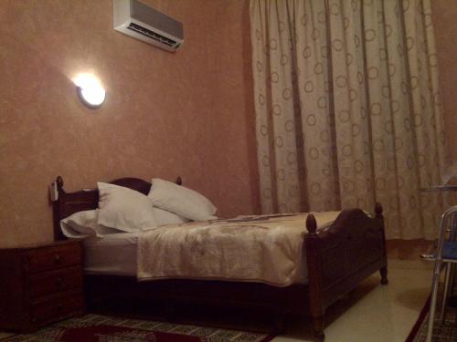 a bedroom with a bed with white pillows at Hotel Espace Tifawine in Tafraoute