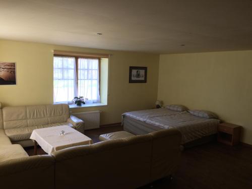 a living room with a couch and a bed at Mežupes in Tūja