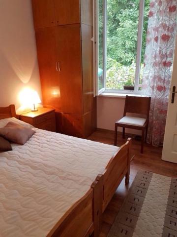 1 dormitorio con cama, ventana y silla en Къща Чалъкови, en Tryavna