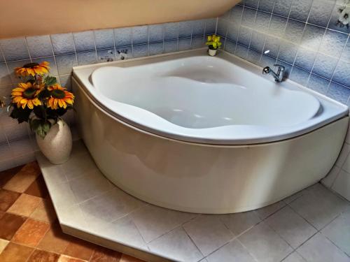 a large white bath tub in a bathroom with flowers at Penzion u Krtka in Kraslice