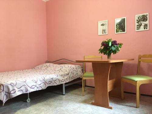 アナパにあるApartment on Terskaya 12のベッド、テーブル、椅子が備わる客室です。