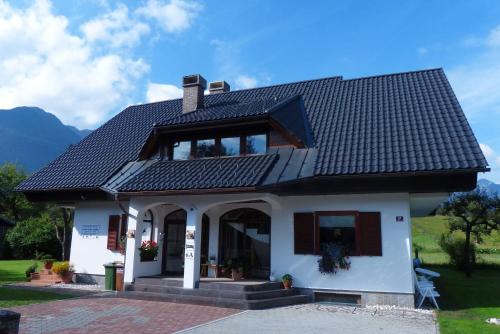 
a large white house with a large window at Guest House Alenka in Bohinj
