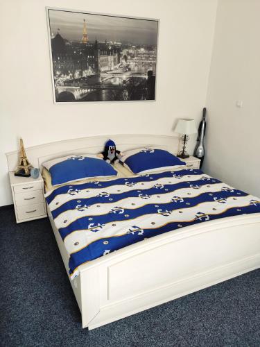 a bedroom with a large bed with blue and white sheets at Penzion u Krtka in Kraslice