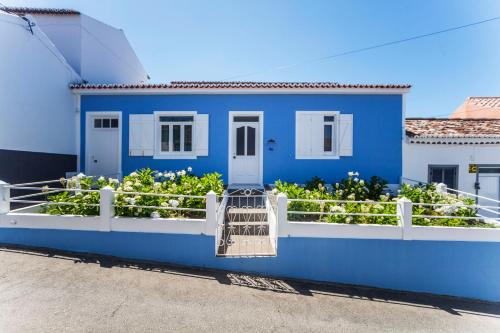 a blue house with flowers on the side of it at Casa da Courela in Nordeste