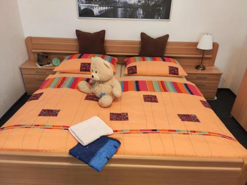 a teddy bear sitting on top of a bed at Penzion u Krtka in Kraslice