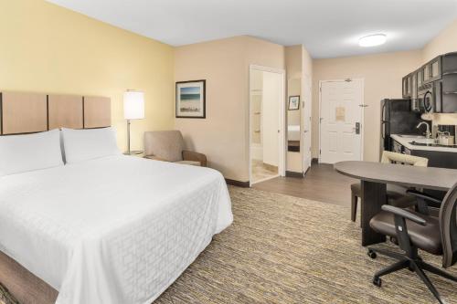 a hotel room with a bed and a desk and a table at Candlewood Suites Destin-Sandestin Area by IHG in Destin