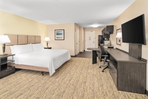 a hotel room with a bed and a desk with a computer at Candlewood Suites Destin-Sandestin Area by IHG in Destin