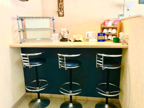 a counter with three bar stools in a room at Asahi City Inn Hotel in Takaoka