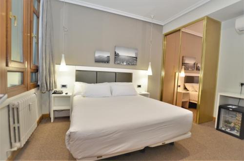 a bedroom with a large white bed in a room at Pensión Alemana in Donostia-San Sebastián