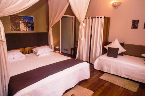 a bedroom with two beds and a window at Les 3 Métis in Antananarivo