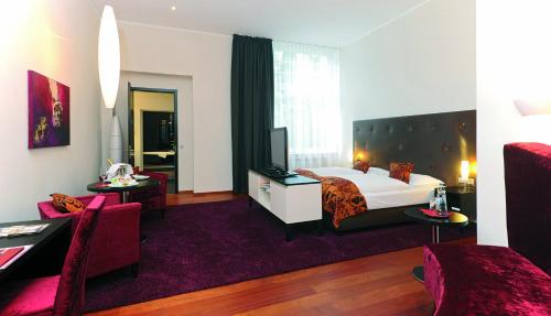 a hotel room with a bed and a tv at Hotel Gräfrather Hof in Solingen
