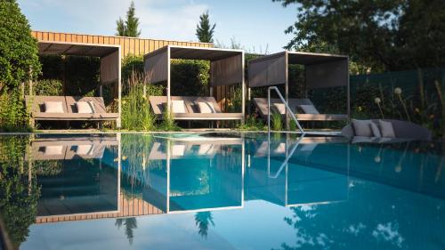 a swimming pool with lounge chairs next to a house at Le Parc Hôtel Obernai & Yonaguni Spa in Obernai