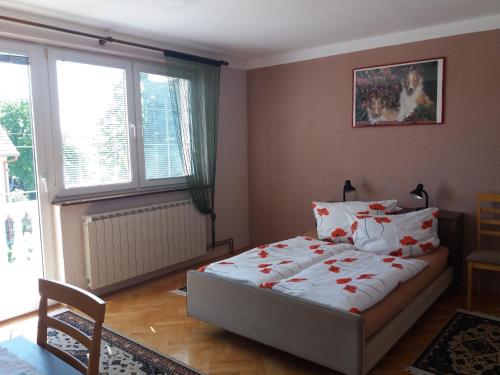 sypialnia z łóżkiem ozdobionym czerwonymi kwiatami w obiekcie Smx Apartement w mieście Prelog