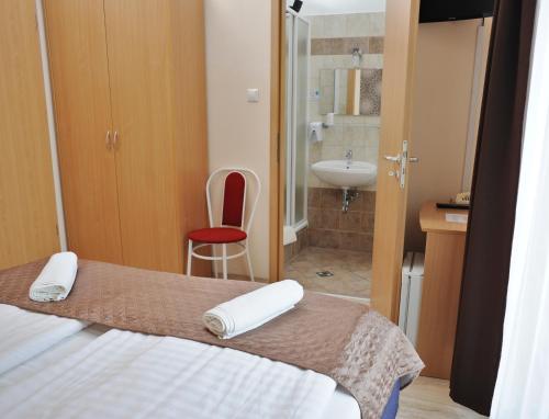 a hotel room with a bed and a dresser at Hotel Papillon in Budapest