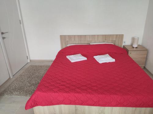 a bedroom with a red bed with two towels on it at Villa Ivanovi in Ohrid