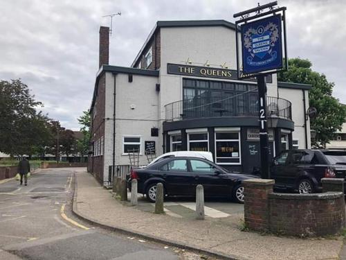 a black car parked in front of a building at The Queens Hostel in London