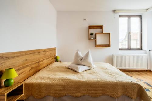 a bedroom with a bed with a wooden headboard at Hotel Carpati in Gura Humorului