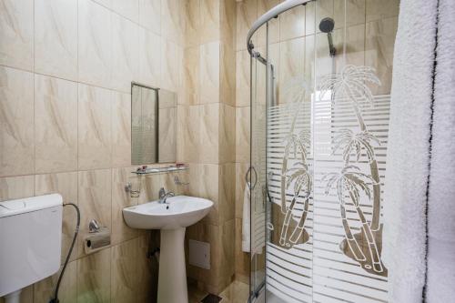 a bathroom with a sink and a shower at Hotel Carpati in Gura Humorului