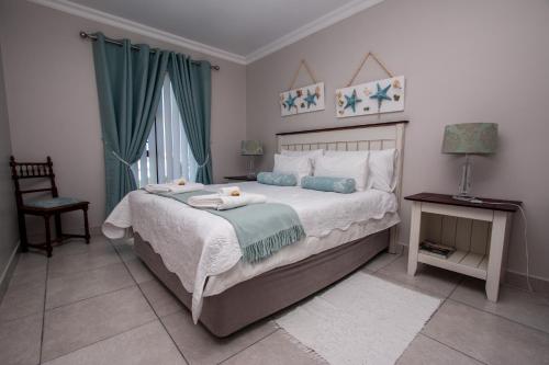 a bedroom with a bed with two towels on it at Van Den Berg's Guesthouse in Bettyʼs Bay