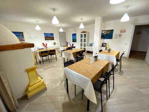 a restaurant with tables and chairs in a room at Janas B&B in Posada