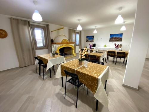 a living room with tables and chairs and a fireplace at Janas B&B in Posada