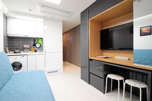 a living room with a tv and a kitchen at Stay 290 in Jeju