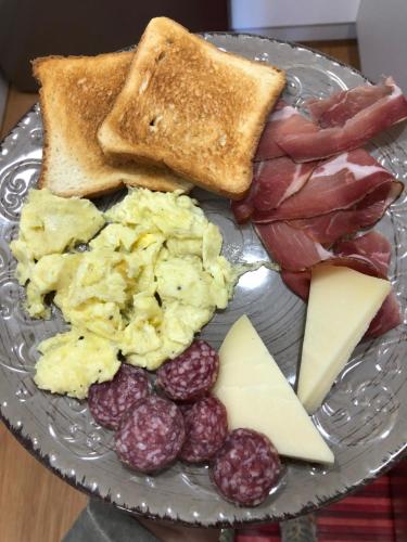 a plate of food with eggs bacon cheese and toast at Boutique Hotel Palazzo Corso Umberto in Boiano