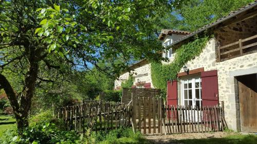 a house with a red door and a fence at Le Moulin de Pensol - Gites in Pensol