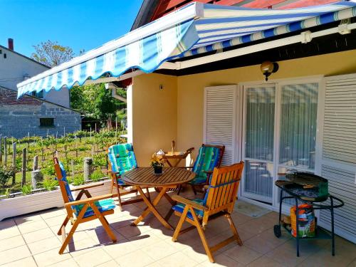 eine Terrasse mit einem Tisch, Stühlen und einem Sonnenschirm in der Unterkunft Villa Felícia in Balatonszepezd