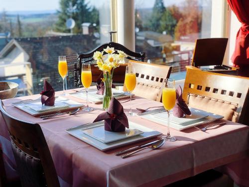 un tavolo con una tovaglia rosa e bicchieri di succo d'arancia di Glashütten Hotel a Glashütten