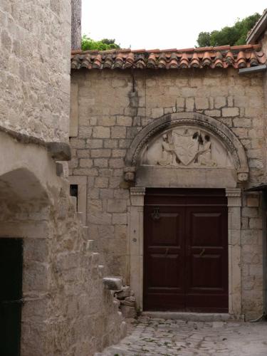 a building with a brown door with a sculpture on it at Villa Kuzmanić in Trogir