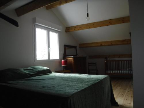 ein Schlafzimmer mit einem Bett und einem großen Fenster in der Unterkunft Gîte Lou Saltret in Montbel