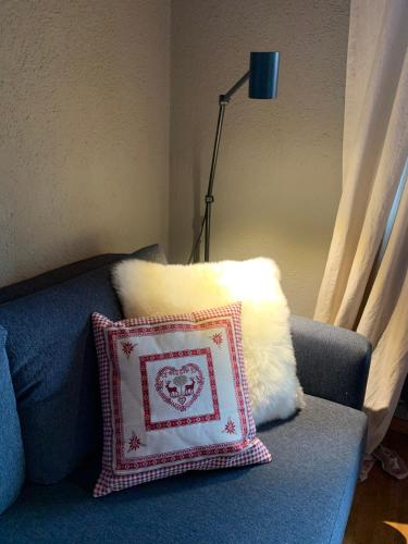 a pillow sitting on a blue couch with a lamp at Ferienwohnung Sunneschii in Davos