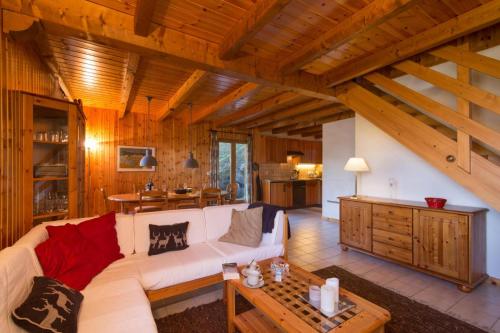 a living room with a white couch and a table at Chalet Mar'Mot in La Tzoumaz