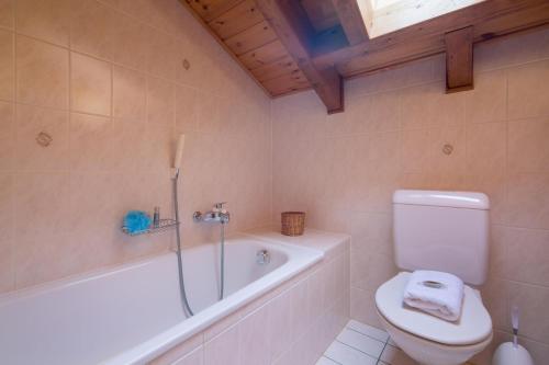 La salle de bains est pourvue de toilettes et d'une baignoire. dans l'établissement Chalet Mar'Mot, à La Tzoumaz