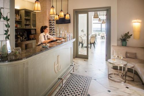 a woman sitting at a bar in a restaurant at Hotel Lido in Alassio