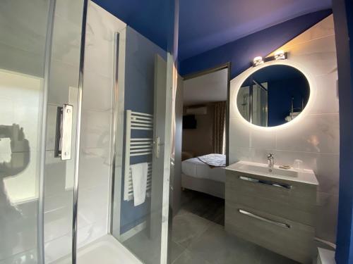 a bathroom with a shower and a sink and a mirror at Hotel Majestic in Nîmes