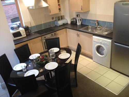 a kitchen with a table and chairs and a kitchen with a washing machine at QuickSpaces Heart of the City in Manchester