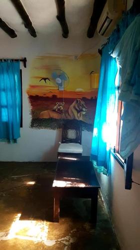 a room with a bench and a painting on the wall at Boutique Hotel Nyumbani Tembo in Watamu