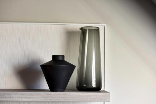 a black vase and a vase on a shelf at Staybridge Suites - Dundee by IHG in Dundee