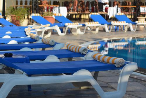 a row of lawn chairs sitting on top of a beach at Oriental Rivoli Hotel & Spa in Sharm El Sheikh