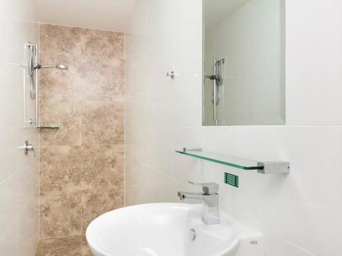 a bathroom with a sink and a mirror and a shower at 19a George Nothling Drive in Point Lookout