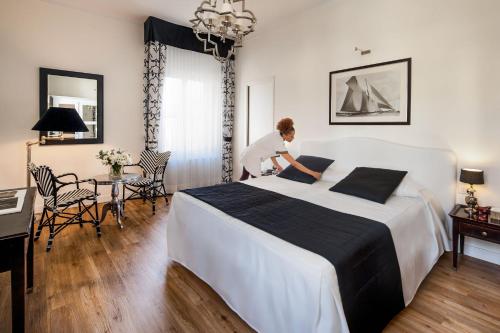 a woman in a hotel room with a large bed at Hotel Lido in Alassio