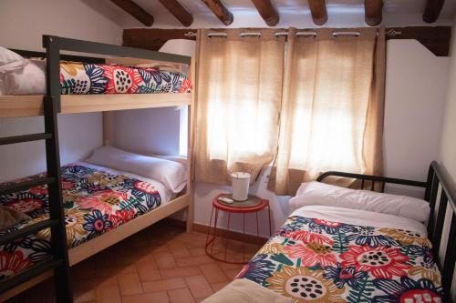 1 dormitorio con 2 literas y ventana en Casas rurales Puente Romano, en Sonseca