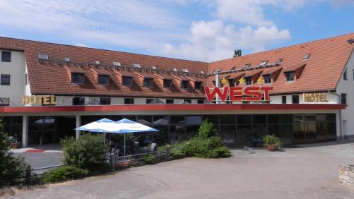 un gran edificio con una señal oeste. en WEST Hotel an der Sächsischen Weinstrasse en Radebeul