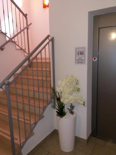 a staircase with a vase of flowers next to a door at Al Cavaliere in Pordenone