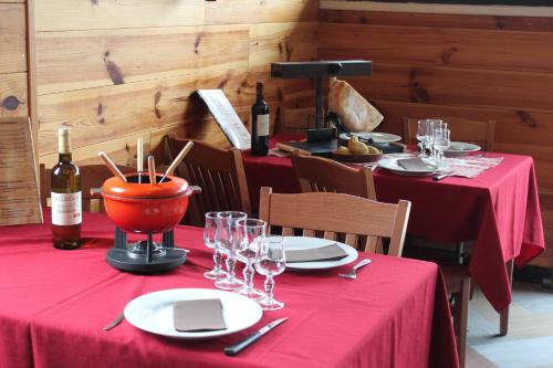 a table with red table cloths and bottles of wine at Ô CHALET 1700 chalet FFS in Saint-Lary-Soulan